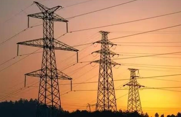 - - Transmission towers silhouetted against an orange sunset, with power lines stretching across the sky.